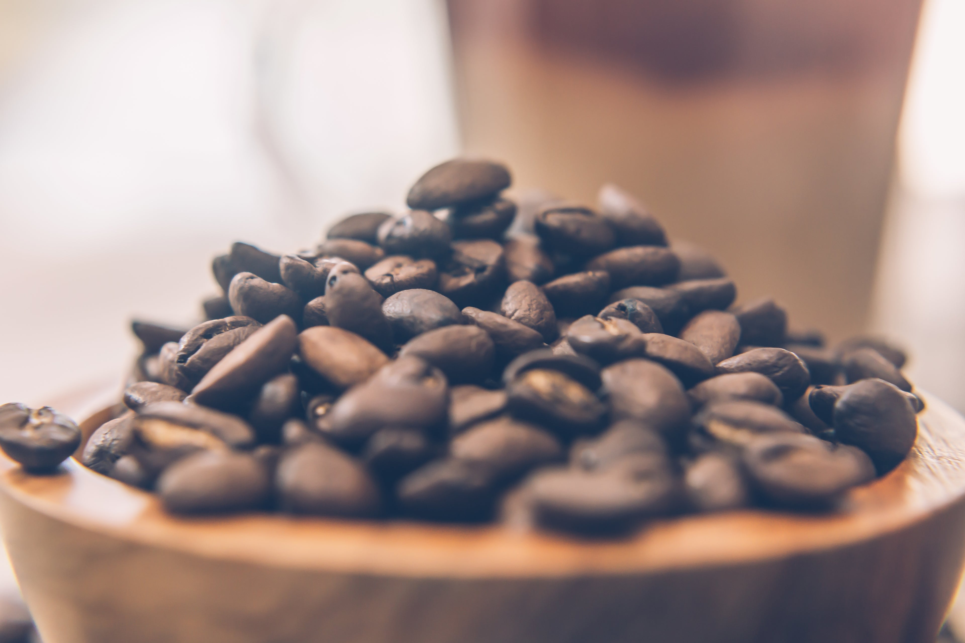 Wooden bowl full of roasted coffee beans